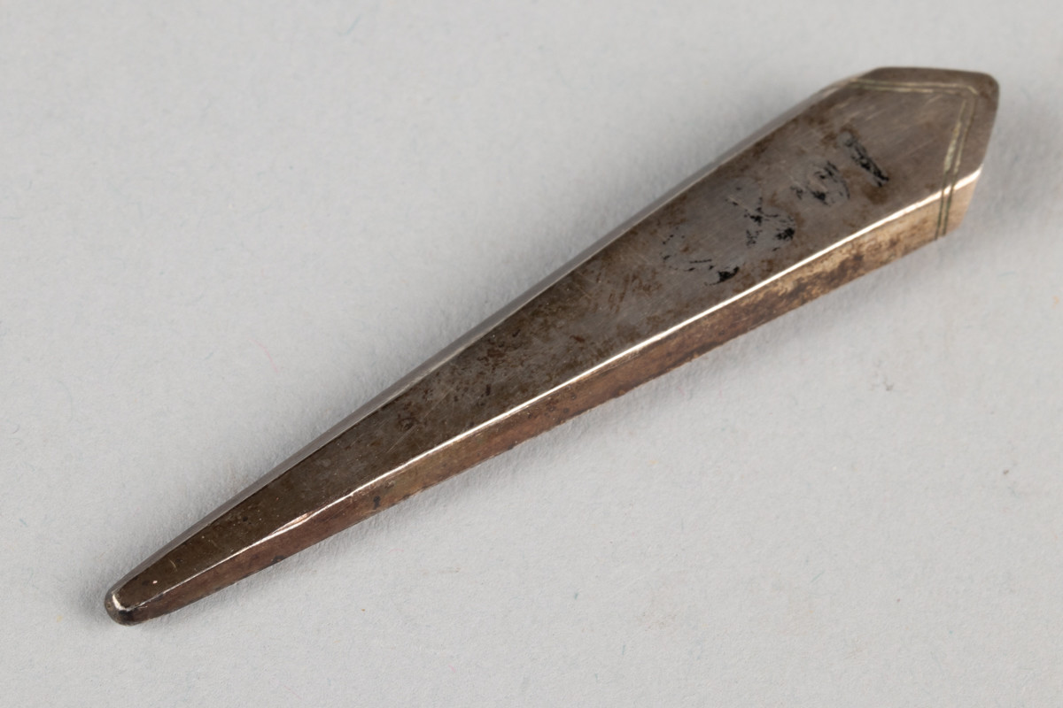 Lite etui til sysaks i metall. Initialene til Anne Marlene Rener Bruun og årstallet 1805 er inngravert