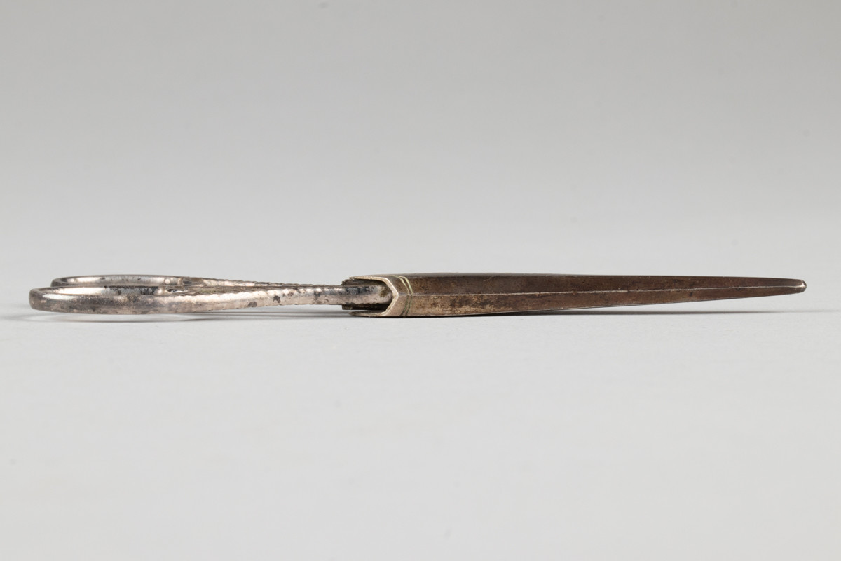 Liten saks for sying og brodering. Saksen har et etui med inngravert initialene til Anne Marlene Bruun og årstallet 1805
