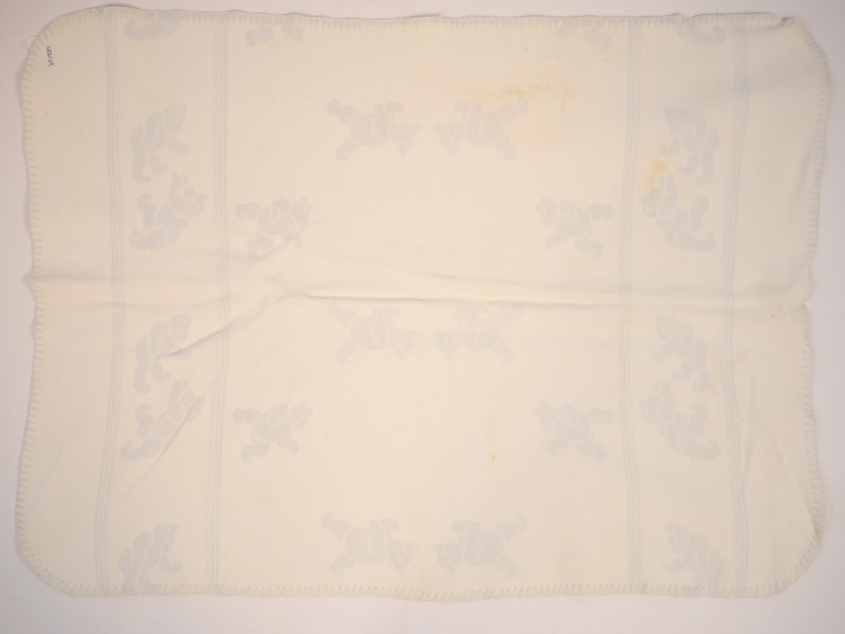 Teppet er kvitt på den eine og blått på den andre sida. På den blå sida er kvite bamsar, på den kvite sida er blå bamsar.