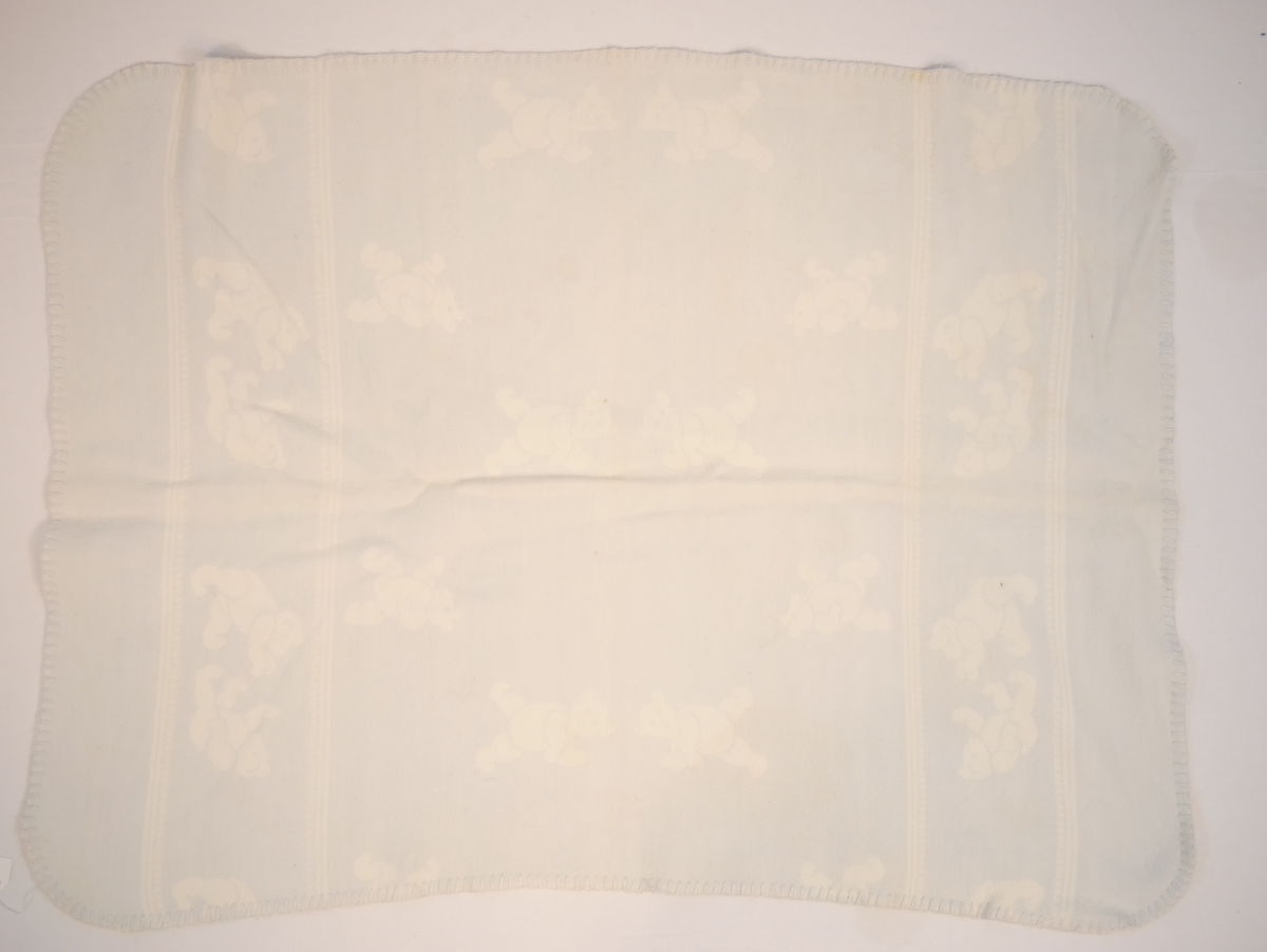 Teppet er kvitt på den eine og blått på den andre sida. På den blå sida er kvite bamsar, på den kvite sida er blå bamsar.