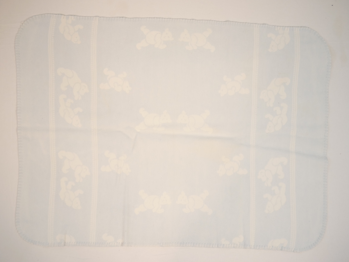 Teppet er kvitt på den eine og blått på den andre sida. På den blå sida er kvite bamsar, på den kvite sida er kvite bamsar.