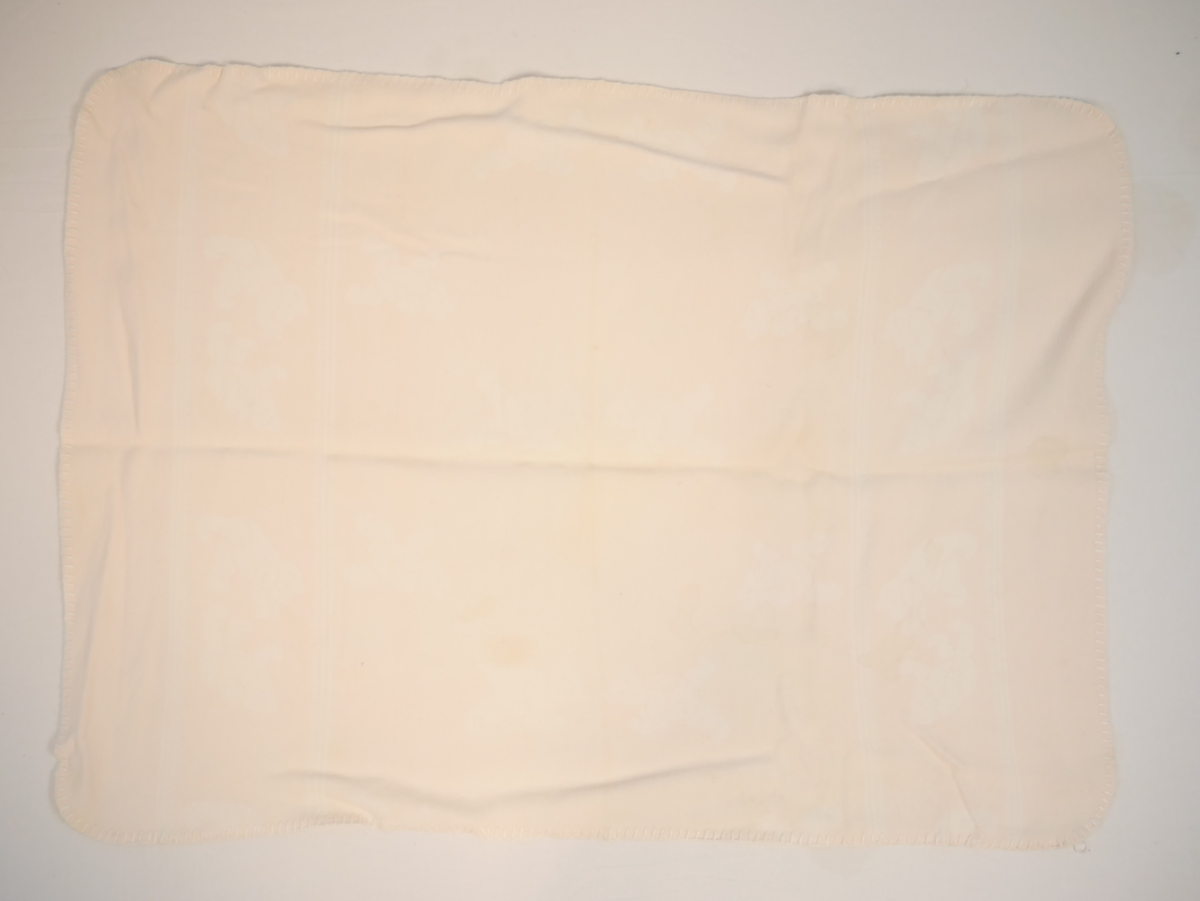 Teppet er kvitt på den eine og rosa på den andre sida. På den rosa sida er kvite bamsar, på den kvite sida er rosa bamsar.