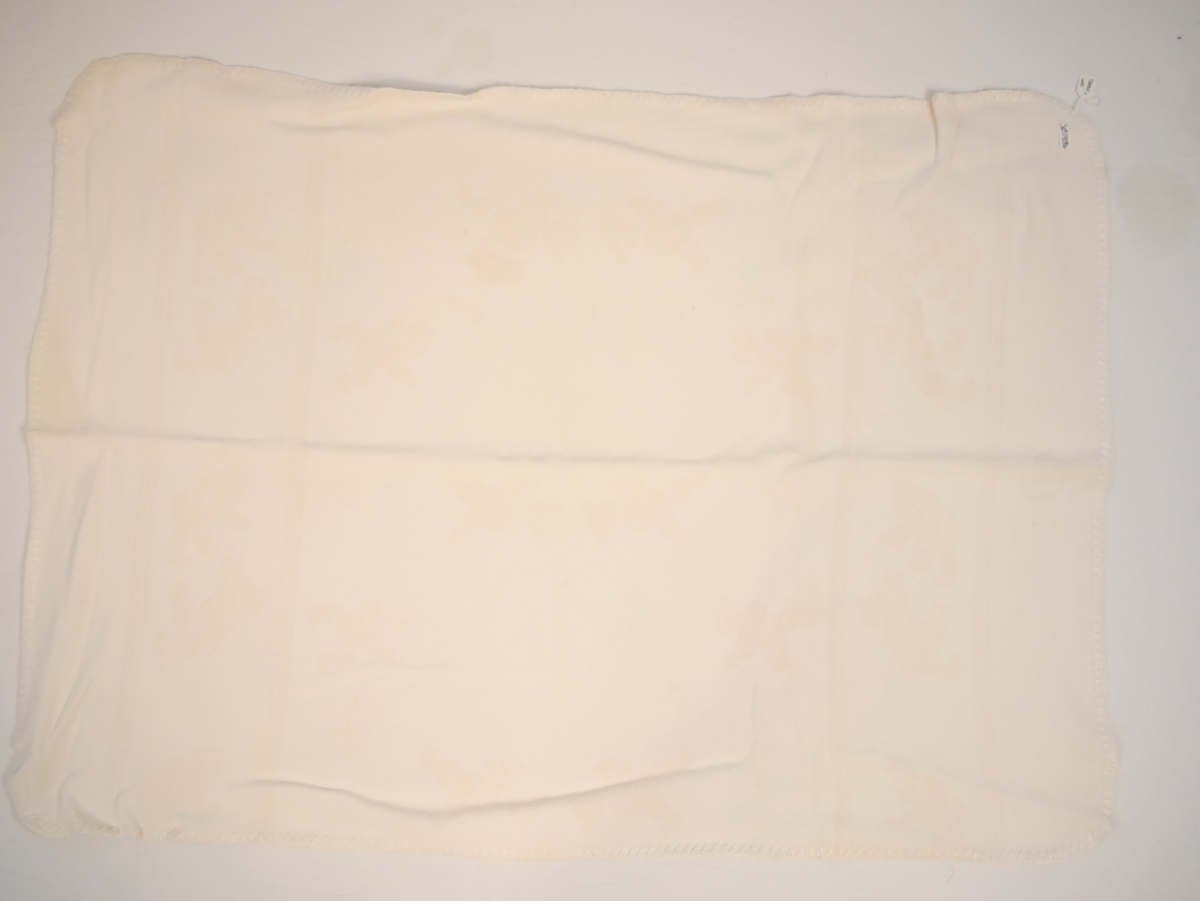 Teppet er kvitt på den eine og rosa på den andre sida. På den rosa sida er kvite bamsar, på den kvite sida er rosa bamsar.