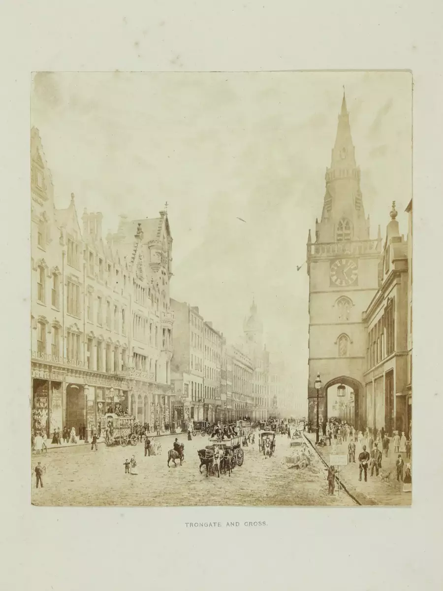 Bildet viser en gate med bygninger på hver side. En kirke bakerst i bildet. Trongate i Glasgow.