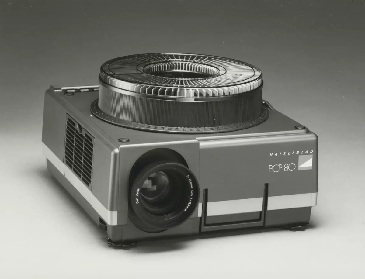 Skisser och ritningar med noteringar och måttangivelser till en projektor för 6x6 diabilder. Även referensmaterial innehållande fotografier och negativ av både modeller och färdig produkt, produktblad, listor på produktfunktioner, materialval m m, avtalsdisposition samt mötesprotokoll.