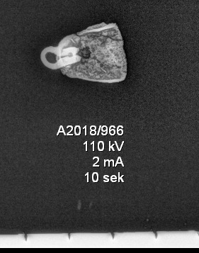 Del av en bjelle av kobberlegering, nærmest lik Egan og Pritchard 2002: fig. 1644. Deler av hempen er bevart, men kolven mangler. Bjellen består av tynt metallblikk, og har et hull på siden, nær hempen. Litt over halvparten av bjellen er bevart. Overflaten er korrodert. L.: 1,4 cm, b.: 0,8 cm, h.: 1,8 cm. Vekt: 2,0 g. 