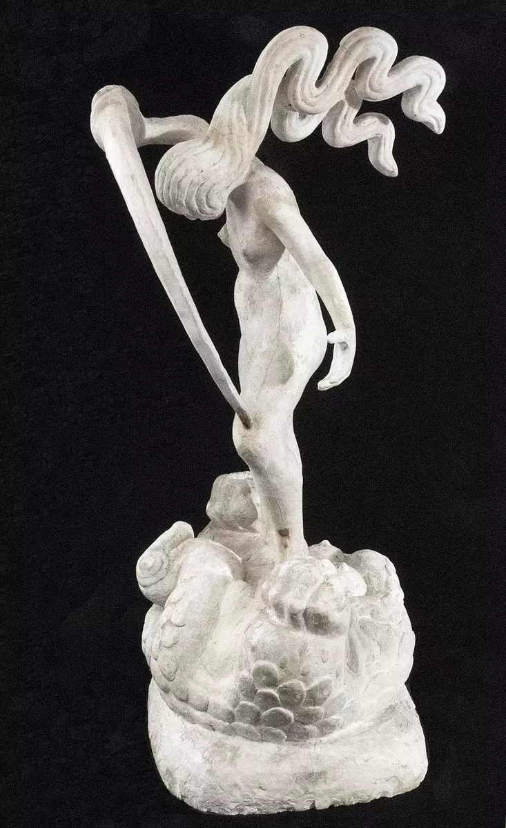 Skulptur. Gips. Figurscen med stående naken kvinna med böljande hår i två horisontella skjåk samt höjt svärdliknande huggvapen. Under kvinnan ligger en drake med sex blottade bröst. Hår med skador. Varken signerad eller dokumenterad, men med största sannolikhet ett verk av Ellen Roosval von Hallwyl.
Nyreg 20130307 JE