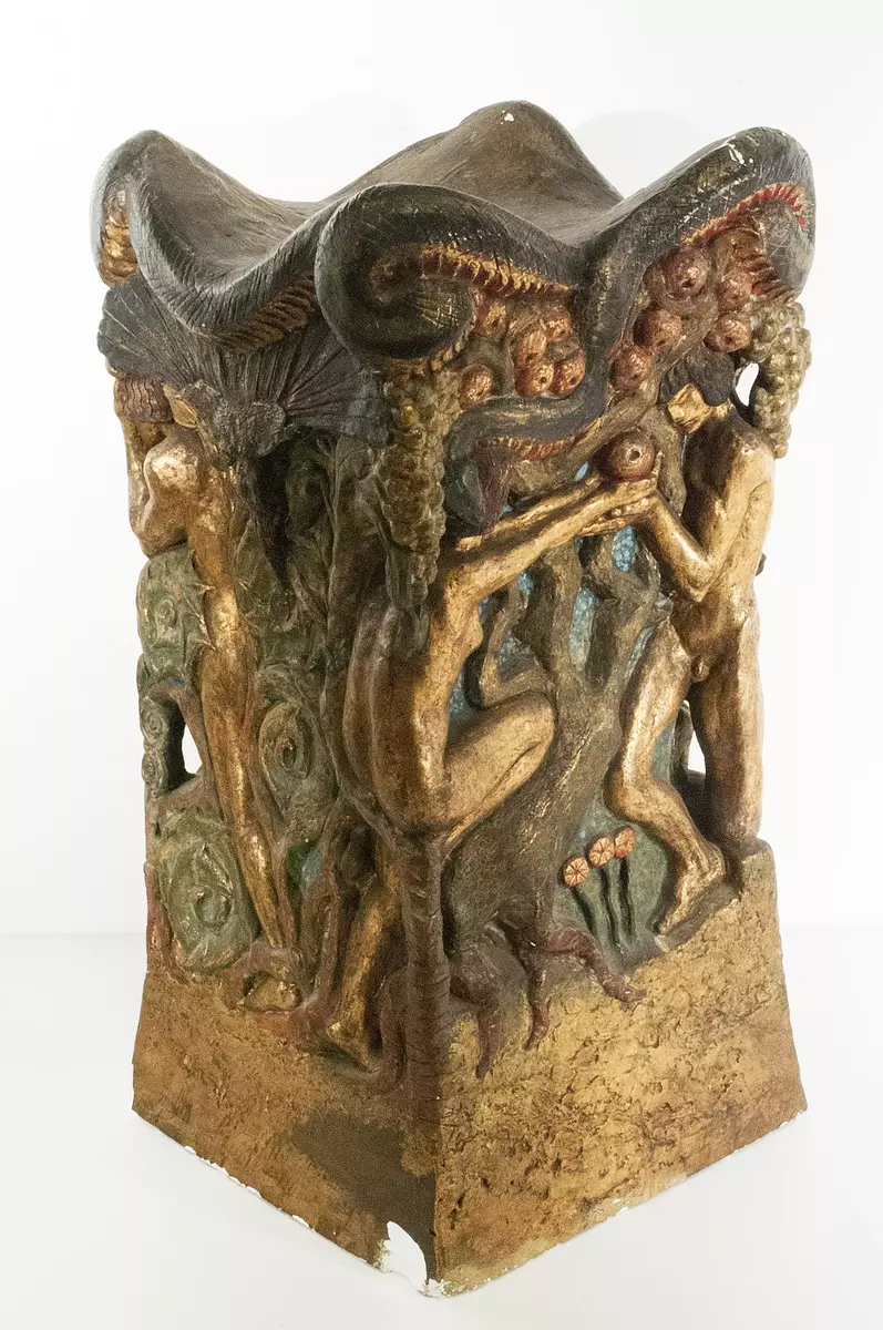 Skulptur. Gips, polykrom och delvis förgylld. "Adam & Eva". Kvadratiskt format kapitäl med fyra olika figurscener från Edens lustgård. Samtliga scener avslutas och sammanförs upptill av slingrande orm.  Nagg längs nederkanten. Johnny kom 1910 att ingå i en kommitté som skulle arbeta fram en ny inredning till koret i Uppsala Domkyrka. För att avskärma korbänkarna föreslog Johnny ett skrank. Detta skulle utsmyckas av kapitäl som Ellen fick förtroendet att utföra. Kapitälen, fyra stycken olika, utfördes i gips 1912-13: "Adam & Eva", "Isaks offrande", "Kristi korsfästelse" och "Kristus i dödsriket". Minst två ("Kristi korsfästelse" samt "Kristus i dödsriket") färdigställdes även skuret i trä samt ett i marmor ("Kristus i dödsriket") och finns i dag på i Hallwylskas samlingar. Av okända anledningar förverkligades aldrig kommitténs förslag och 1917 lade man ner projektet. Kapitälet syns bland annat i Ideströms byggnadsdokumentation från 1987 samt i en ej målad version i en artikel i tidskriften Konst & Konstnärer, nr. 10, 1913.
Nyreg 20130304 JE