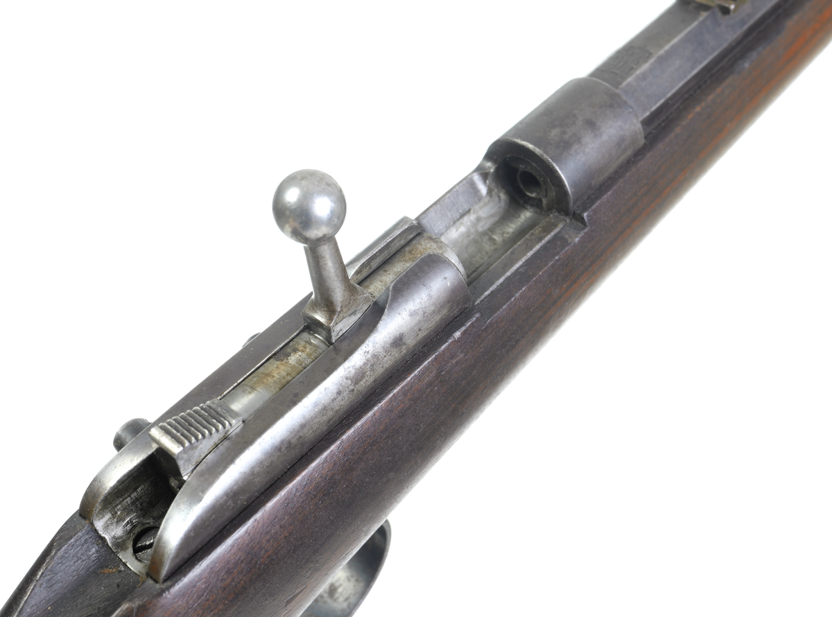 Husqvarna enskotts salongsgevär i kaliber 22 med kantantändning. Geväret är försett med cylindermekanism. Pipan är åttakantig och försedd med ståndsikte utan klaff, samt har ett spetskorn infällt i pippan. Pipan är invändigt räfflad. Kolven är tillverkad i valnöt, helt slät och odekorerad. Bakplåten är i stål och är blånerad. Även pipa och låda är blånerade. Endast slutstycket är blankpolerat.
Inskrivet i huvudkatalogen 1969.