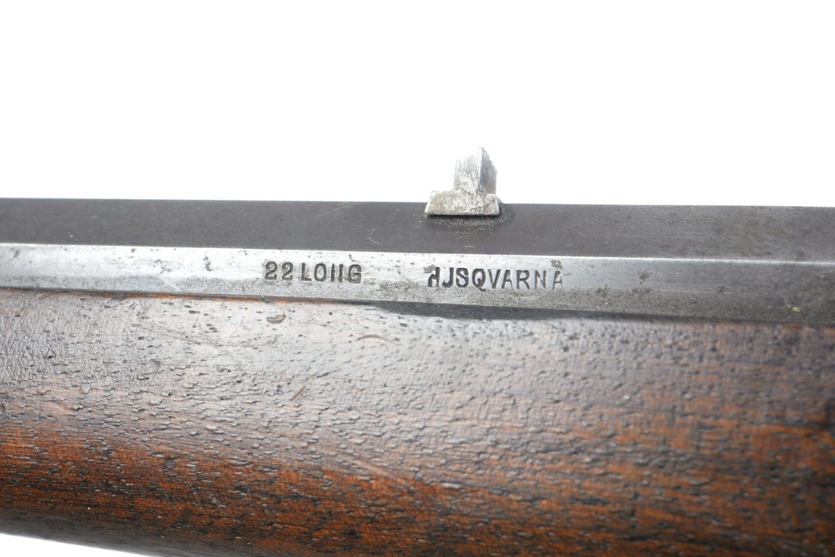 Husqvarna enskotts salongsgevär i kaliber 22 med kantantändning. Geväret är försett med cylindermekanism. Pipan är åttakantig och försedd med ståndsikte utan klaff, samt har ett spetskorn infällt i pippan. Pipan är invändigt räfflad. Kolven är tillverkad i valnöt, helt slät och odekorerad. Bakplåten är i stål och är blånerad. Även pipa och låda är blånerade. Endast slutstycket är blankpolerat.
Inskrivet i huvudkatalogen 1969.