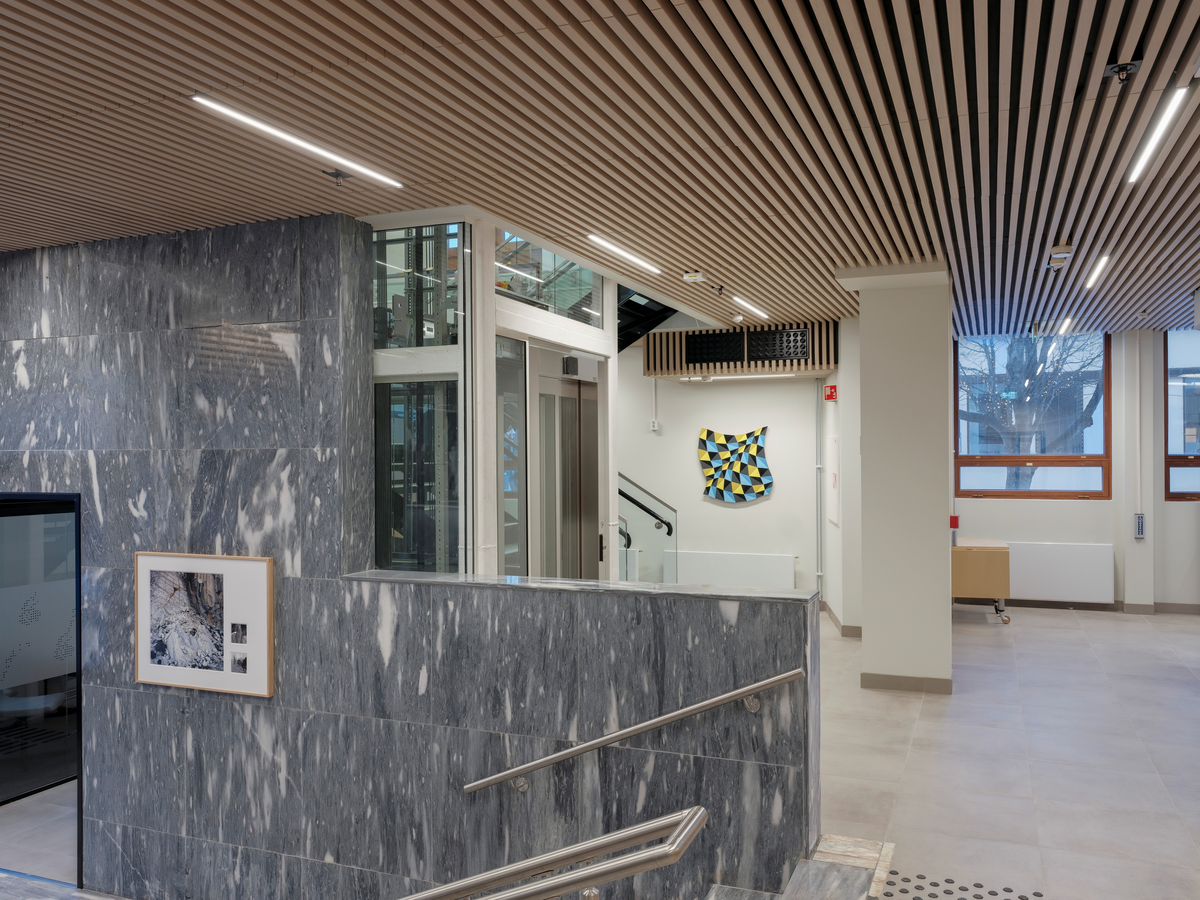 Monica Flakk bor og arbeider i Oslo, der hun også er utdannet på Kunsthøgskolen. Kjernen i hennes produksjoner omhandler steiner og fjell, som formidles gjennom fotografi og avstøpninger. Kunstverket "Marks in the Archive #1" består av ulike fotografiske utsnitt med naturstein, som er satt sammen til en komposisjon. Utsnittene bidrar til en anonymisering av geografiske beliggenhet og størrelse. De blir fragmenter av en større helhet, der farger, strukturer og den geologiske historien fremheves. Fotografiene i samspill blir et fortellende grep som forsterkes ved at verket er montert direkte på fauskemarmoren i lokalet, og knyttes opp til bygget i seg selv.