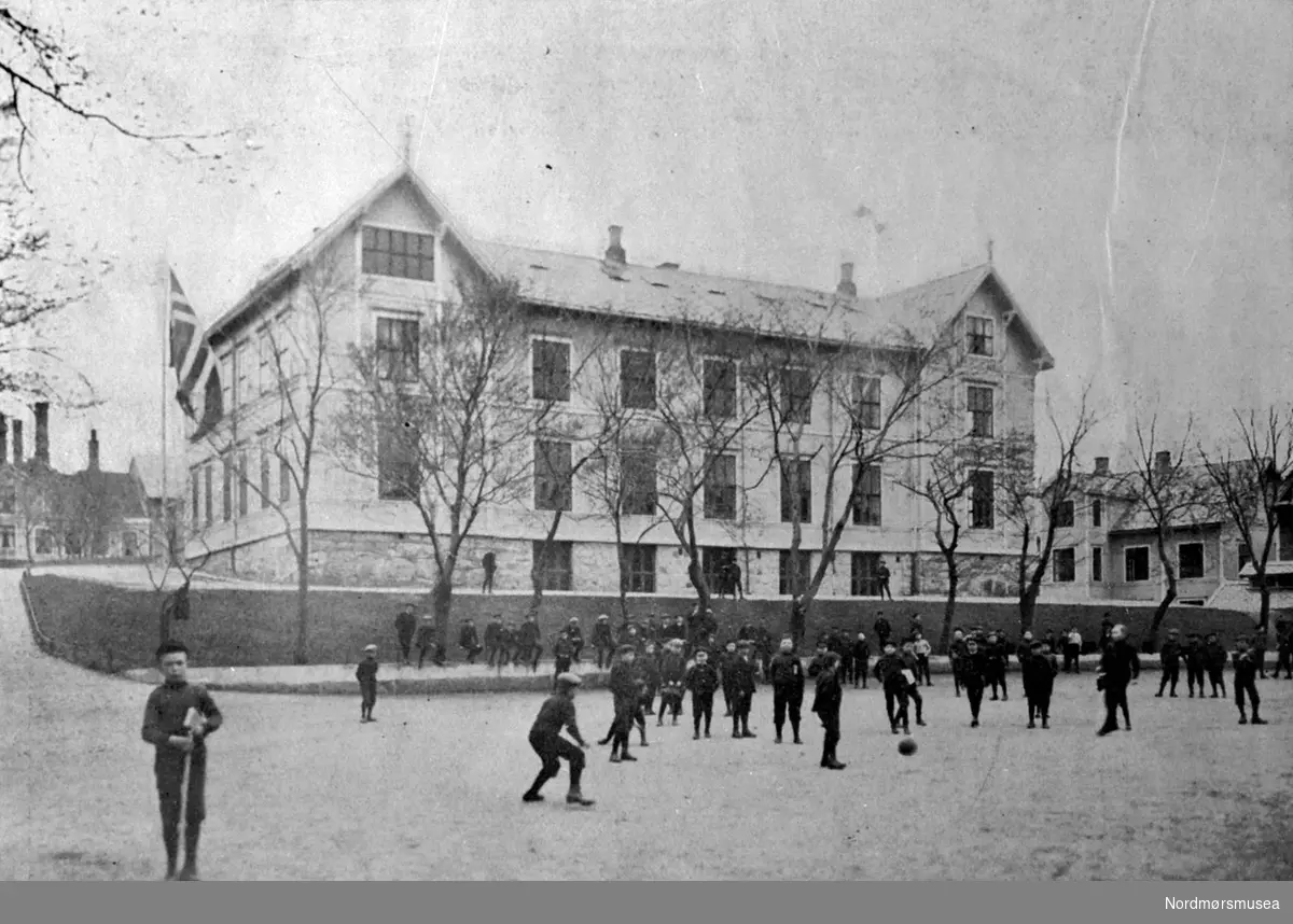 Foto av barn på skoleplassen ved Latinskolen i Skolegata på Kirklandet i Kristiansund. Reprofotografering utført av Nils Williams.