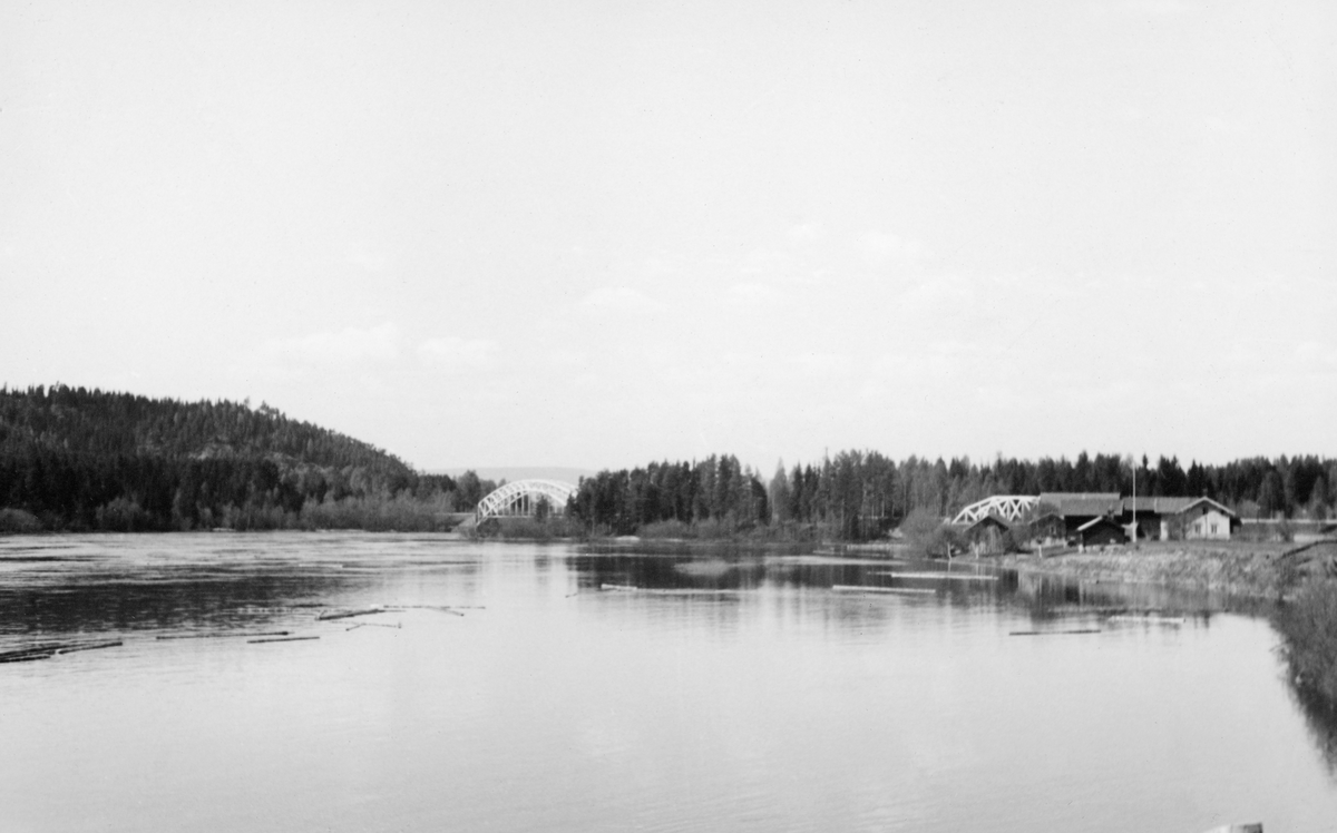 Dammen ved Skjefstadfossen i Heradsbygda i Elverum, fotografert fra et landkar, en plattform ved den østre enden av dammen. Bildet ble tatt i mai 1941. Det fløt en del løstømmer på vannspeilet. Ved østre elvebredd – til høyre på bildet – ser vi småbruket Fossum. Der bodde Fossum-karene, legendariske fløterbaser, dam- og båtbyggere i denne regionen. Bakenfor ser vi Haugsøya med fagverksbruer mot østre og vestre elvebredd, der Solørbanen krysset vassdraget.