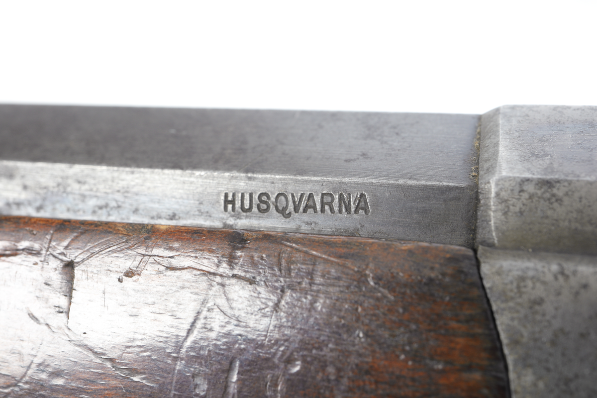 Husqvarna enskotts jaktgevär med centralantändning. Geväret är försett med mekanism av typen Rolling-Block. Pipan är åttakantig och försedd med ståndsikte med klaff för olika avstånd samt har ett spetskorn infällt i pippan. Pipan är invändigt räfflad. Kolven är tillverkad i valnöt och har en kolvhals som är neddragen som en pistolkolv, där pistolgreppet är nätskuret. Bakplåten är i stål och är blånerad. Även pipa och låda är blånerade. 
Inskrivet i huvudkatalogen 1969.