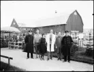 Stockholmsutställningen 1930
Gruppbild. Sex personer stående framför en ladugård med reklam för eternit