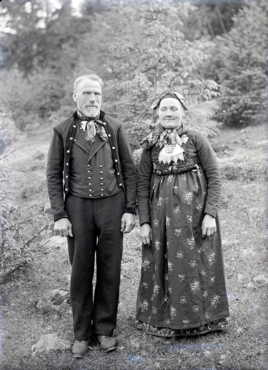 Hallingdal, Nesbyen kommune, Øvre Børdalen, ekteparet gårdbruker Amund Bjørnsen Børdalen (22.06.1846-15.12.1931) og Barbro Engebretsdatter født Rime i Flå  (08.10.1849-24.05.1932) i folkedrakter fra Flå i Hallingdalen, Hallingbunad, kona i bunad fra Flå i Hallingdal, dette er foreldrene til Engebret Amundsen Børdahl, 
Informasjon: Knut Brøto, Nesbyen, Hallingdal