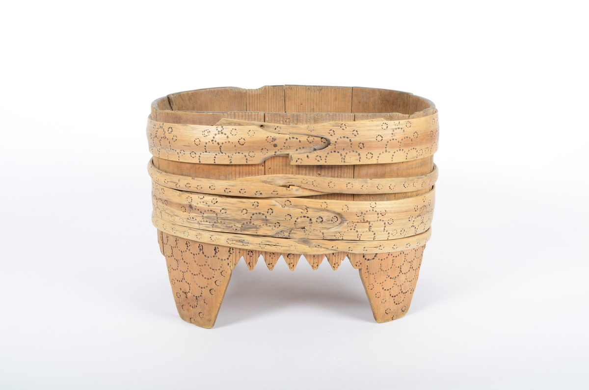Tre, umalt. Lagget, furu. Ti staver, fire ben. Fire gjorder, to brede og to smale, som sammen dekker stetten ovenfor bena. Kantene mellom bena er takkete. Stetten er oval. Rikt dekorert med svidd ornamentikk. Bare gjordene er dekorert ovenfor bena. Svidd ornamentikk under bunnen.