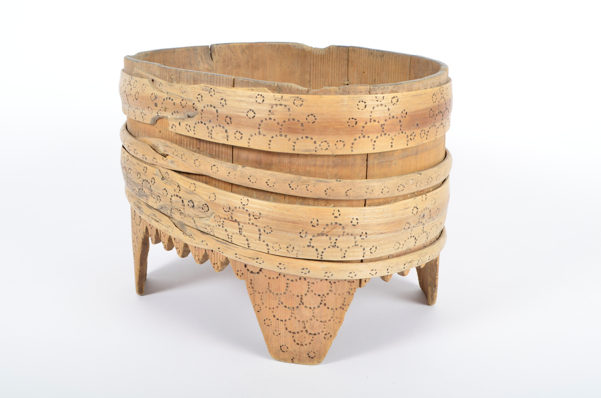 Tre, umalt. Lagget, furu. Ti staver, fire ben. Fire gjorder, to brede og to smale, som sammen dekker stetten ovenfor bena. Kantene mellom bena er takkete. Stetten er oval. Rikt dekorert med svidd ornamentikk. Bare gjordene er dekorert ovenfor bena. Svidd ornamentikk under bunnen.