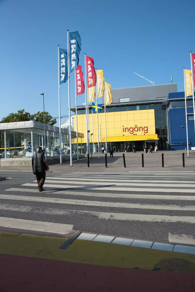 En man korsar Modulvägen mellan Kungens kurva shoppingcenter och IKEA.