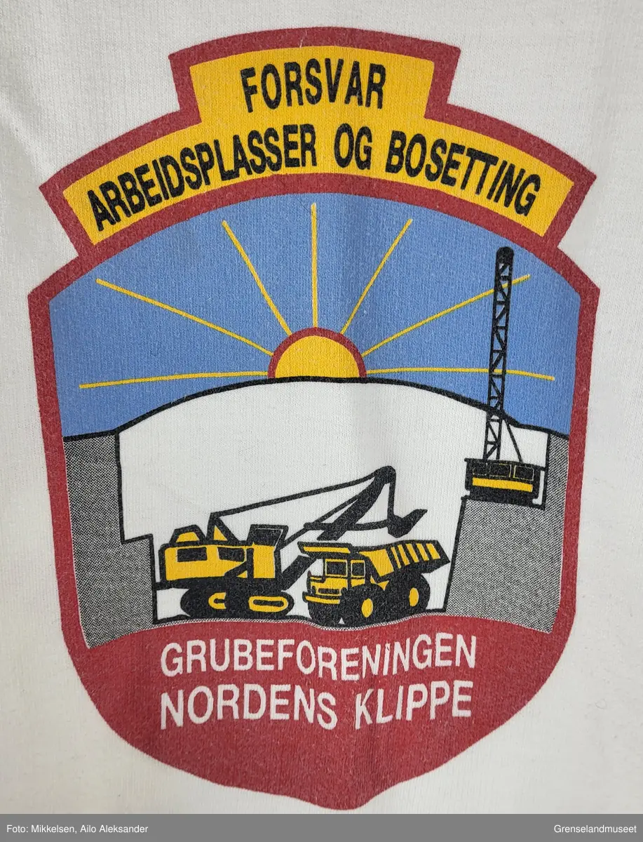 En langarmet hvit genser med logoen til Grubeforeningen Nordens Klippe på forsiden og på ryggen i rød skrift "Grubeforeningen Nordens Klippe".