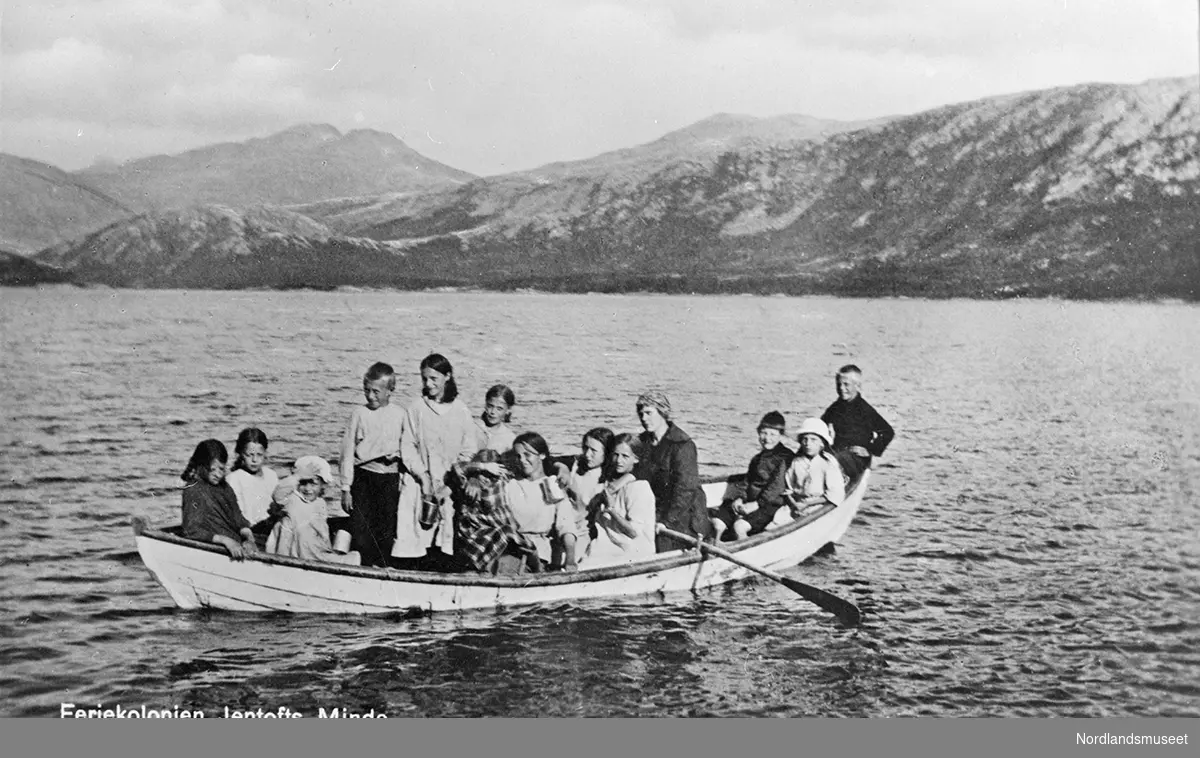 Fra feriekolonien Jentofts Minde, ved Vatenvatnet. Unger på båttur. 10 jenter og 3 gutter. En voksen person sitter ved årene.