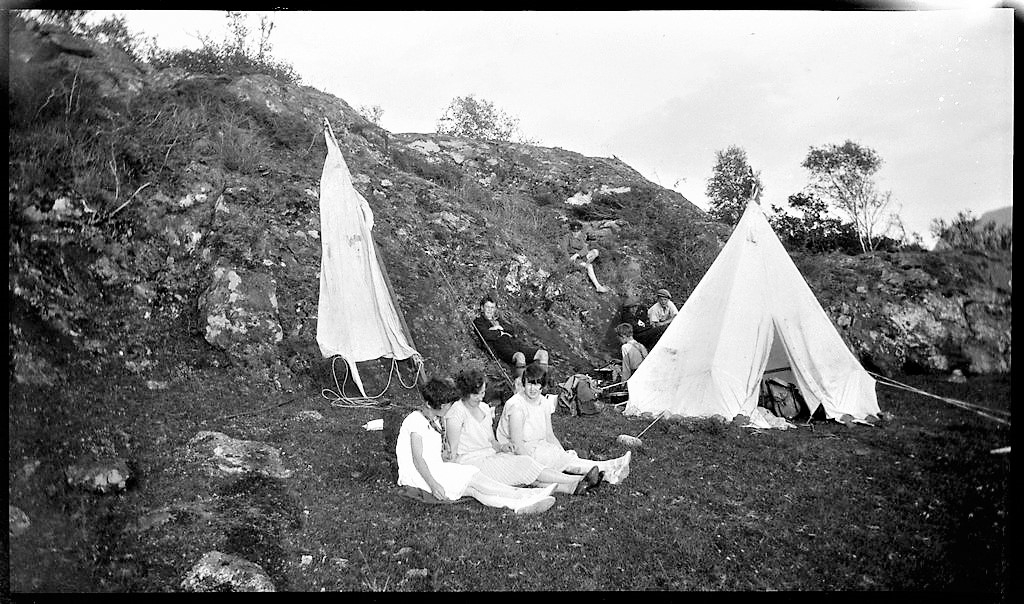 Unge menn og gutter på tur med ro- og seilbåt i Ryfylke. Det er bilder fra båtturene, bading, teltliv og turer på landet og i fjellet. Noen av guttene går med speiderskjorte.