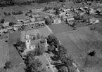 Flygfoto över Skattungbyn. Skattunge kyrka år 1953. Läs mer om Skattunge kyrka i boken: Dalarnas kyrkor i ord och bild.