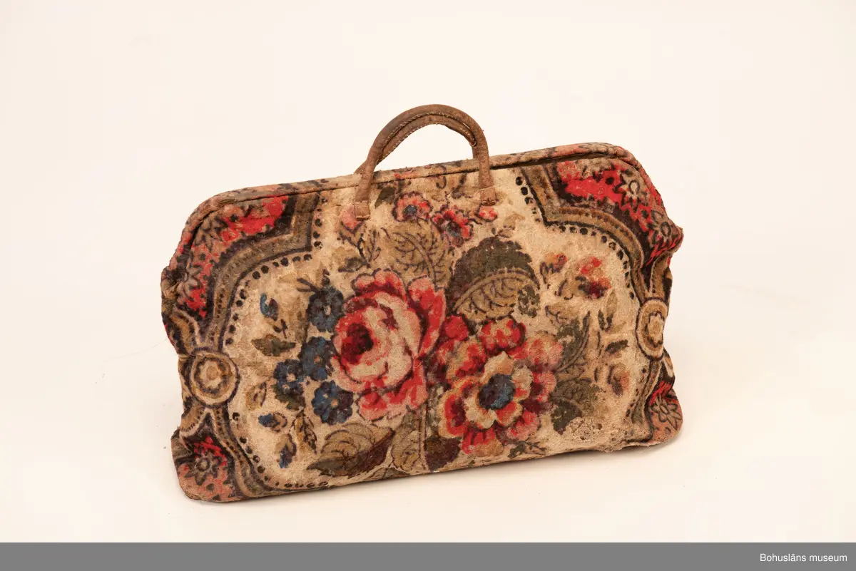 Ur handskrivna katalogen 1957-1958:
Rosig nattsäck
L. 51. H: (med handtag) 41. Av filttyg med blommigt mönster. Smärre hål. 
Från Kärra (U-a)