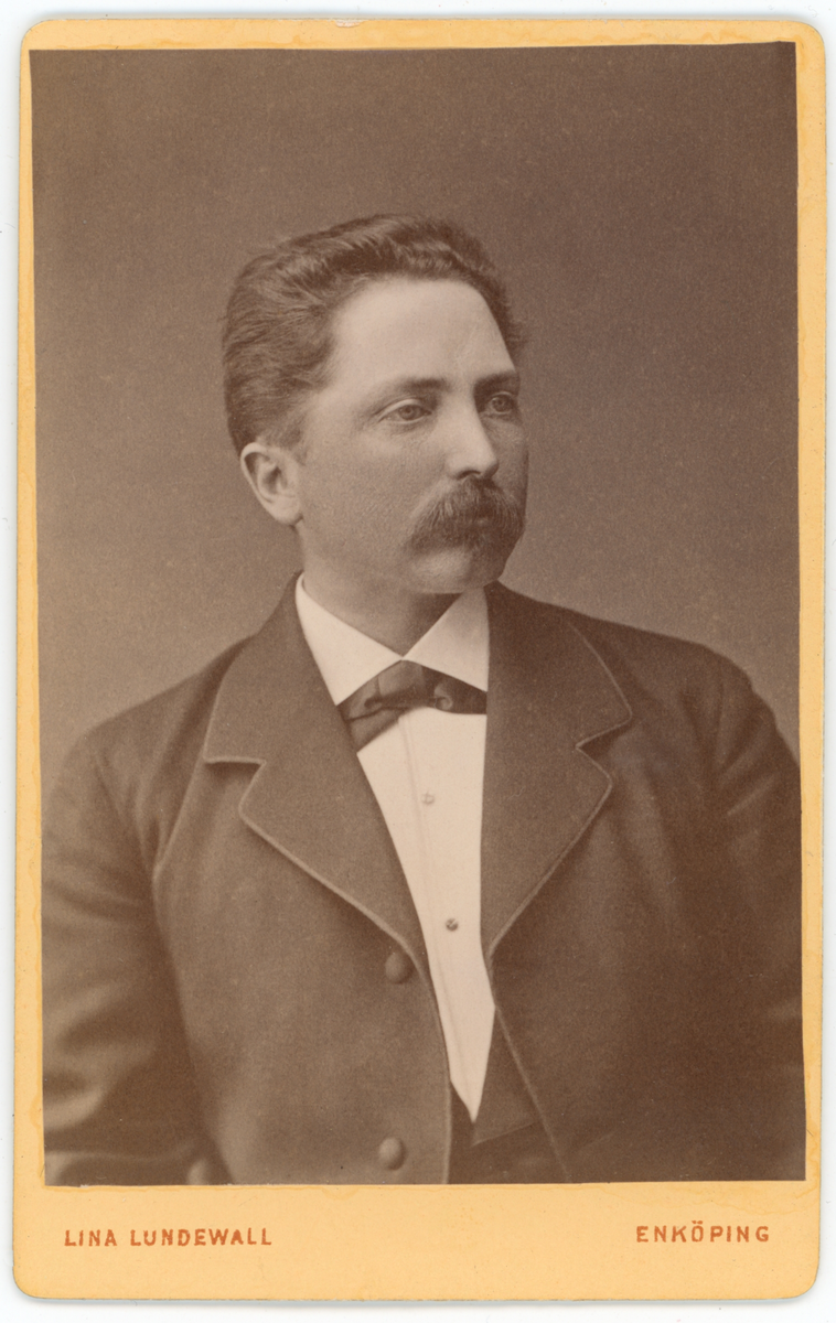 Svartvit ateljéporträtt av okänd man.