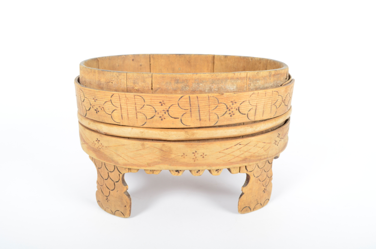 Trekar i furu og bjørk. Lagget, oval form, fire høye ben. To brede gjorder med en vidje i mellom. Sviornamentikk på gjorder og ben.