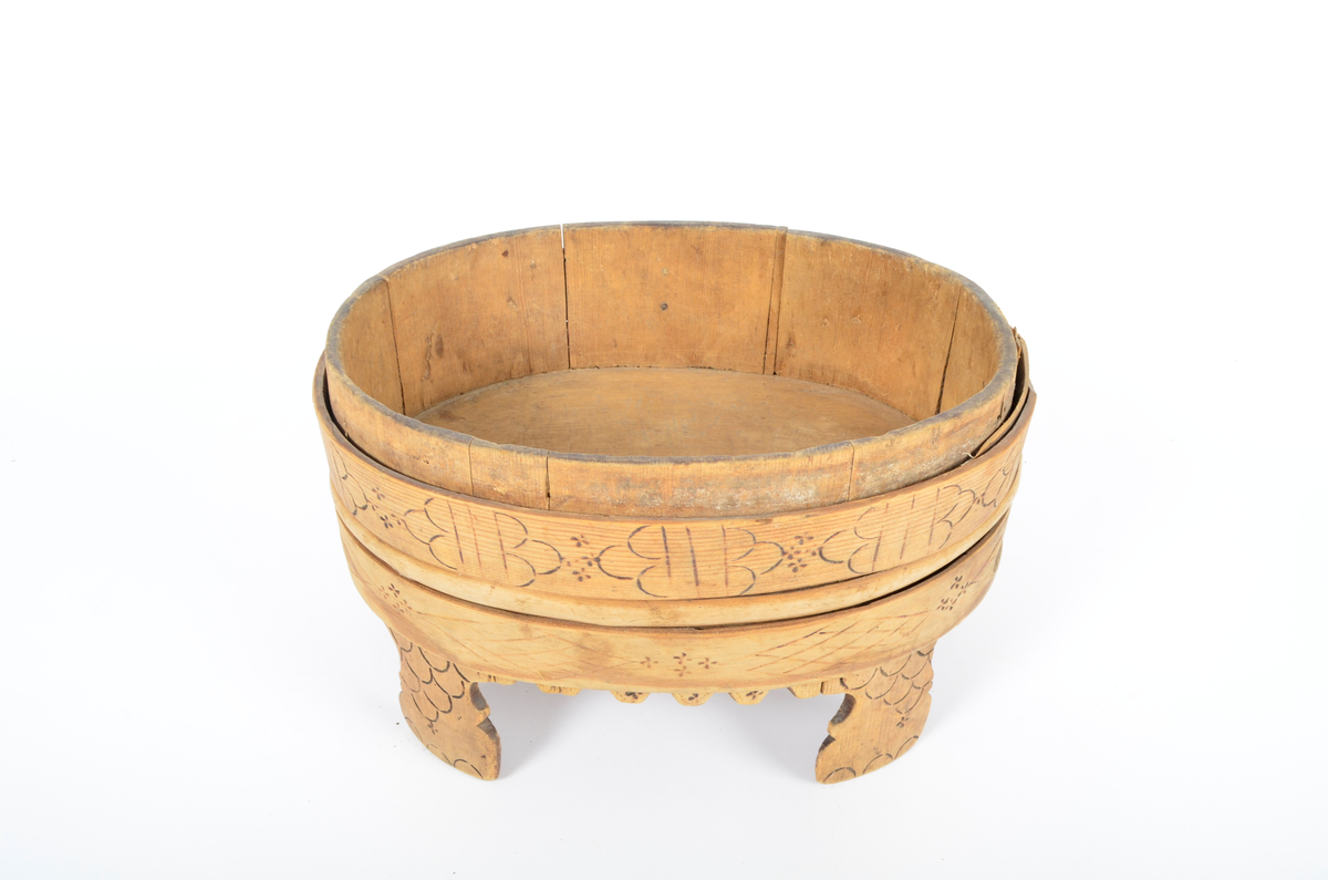 Trekar i furu og bjørk. Lagget, oval form, fire høye ben. To brede gjorder med en vidje i mellom. Sviornamentikk på gjorder og ben.
