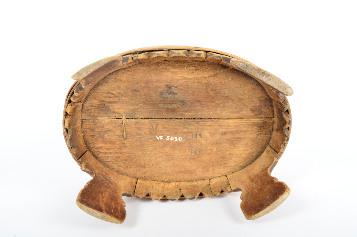 Trekar i furu og bjørk. Lagget, oval form, fire høye ben. To brede gjorder med en vidje i mellom. Sviornamentikk på gjorder og ben.