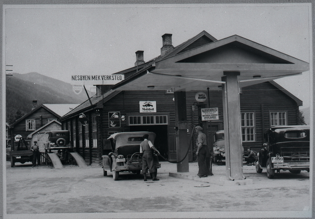 Bensinstasjon, bilverksted
Nesbyen Mek, verksted var firmanavnet da bildet blei tatt i 1934-35, men blei først registrert hos sorenskriveren 16.juni 1947. Andres Bergo fyller bensin og ved bensinpompen står Johannes Nässelqvist
