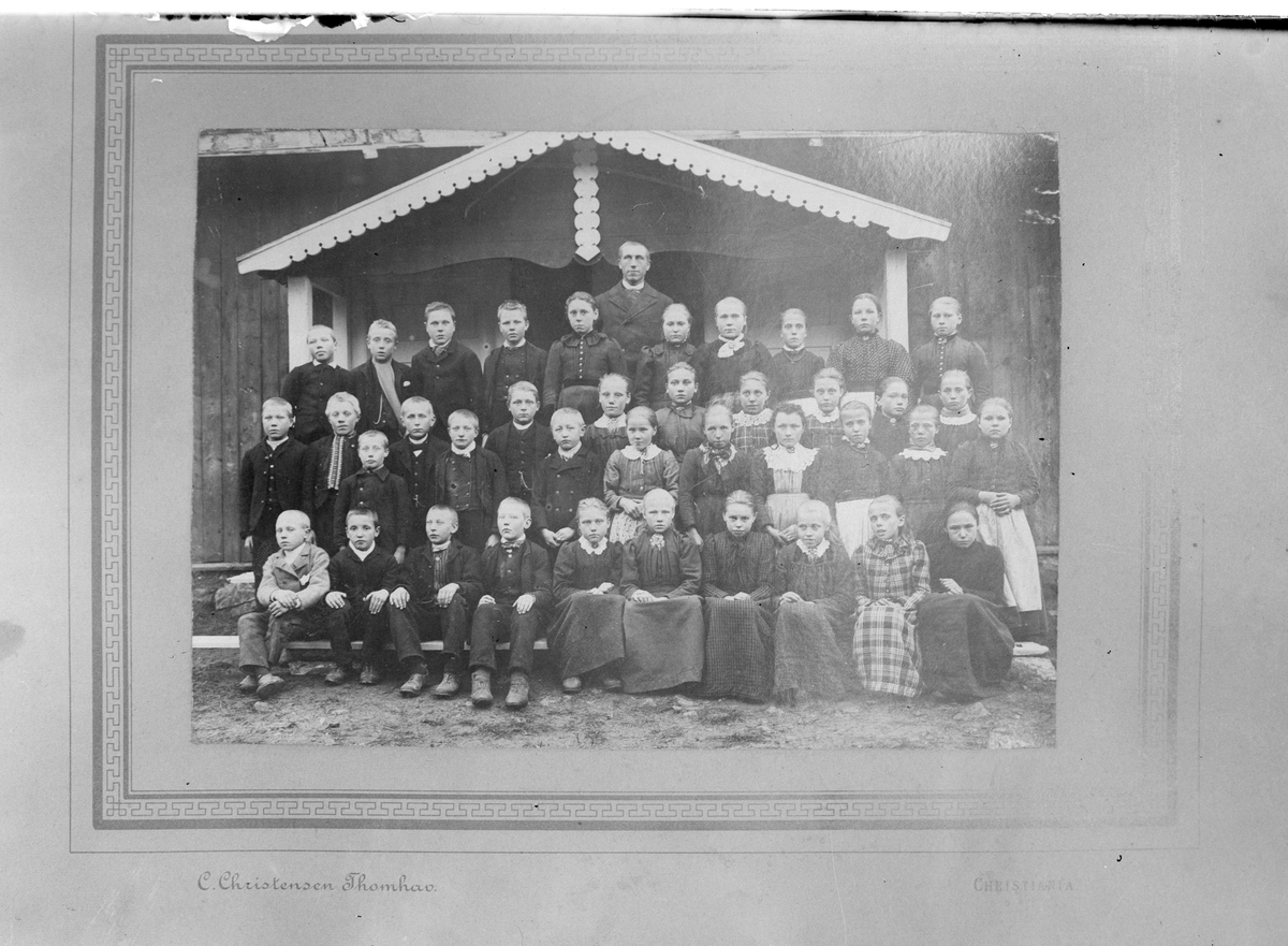 Skolebilde
Lærer Lødøen med elever ved Eidal skole i 1897. De står utenfor inngangen til skolen. Fin utskjæring på vindskia på verandataket.
