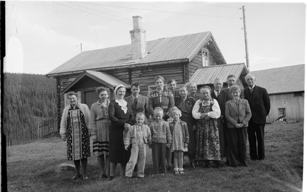 Familiene Langslet/Moen foran en tømmerbygning. T.v. Alma Langslet og t.h. Lars Roar Langslet.
