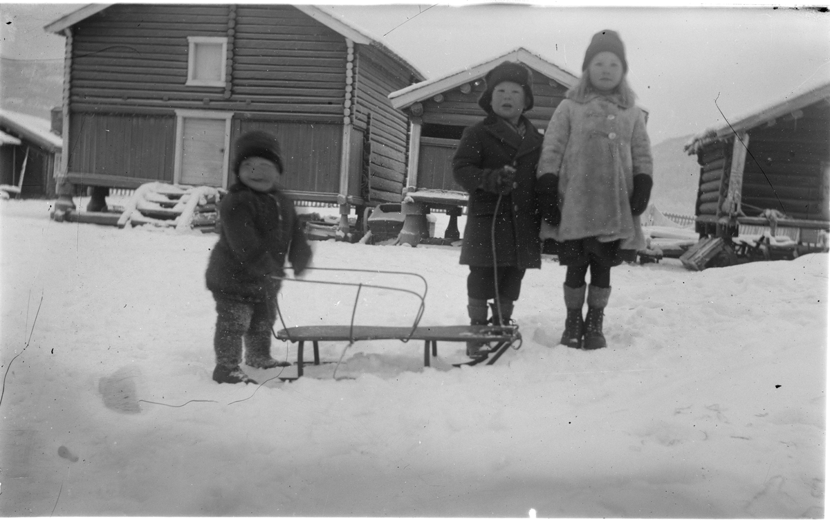 Barn i gardstun
F.v. Ole Ulrik Schack. Paul Schack og Alvilde Schack med kjelke foran stabburene i Hagale.
