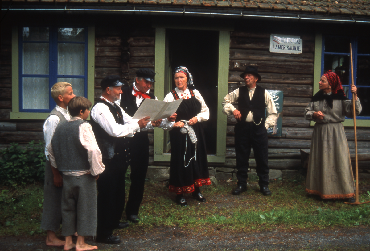 Fra Emigrantspelet 2002. Ved landhandelen. F.v.Tov Løvgaard, Simon Strand, Jan Erik Lien (postmann), Per Egil  Kolsrud, Agnes Aasen, Birger Bakkeplass, Kari Bergaplass.
