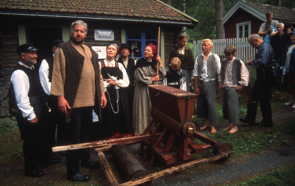 Fra Emigrantspelet 2002.Ved landhandelen. F.v. Jan Erik Lien, Leif Otto Moen, Agnes Aasen, Birger Bergaplass, Kari Bergaplass, Vilde Dokk, Guro Dokk, Simen Strand, Tov Løvgaard, Per Liahagen (skomaker).
