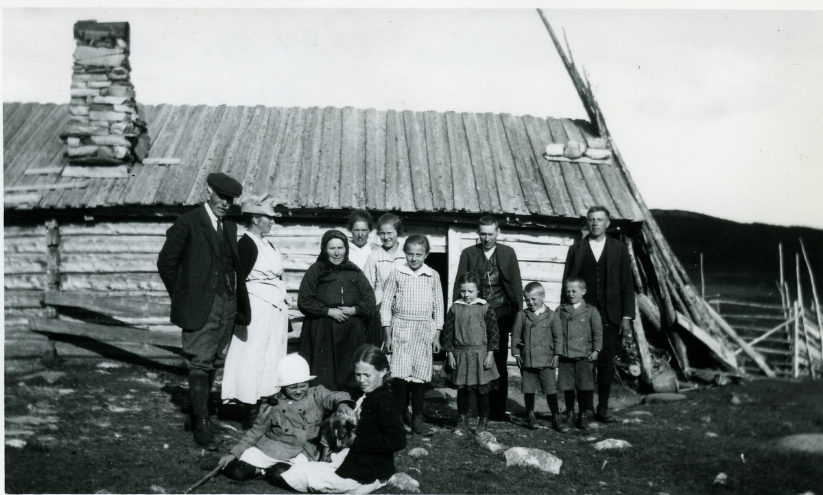 Gruppe ved seterbu
Familien Sveinsson Fra v. Olav Sveinsson ( f. Høllo) 1854-1927, Caroline Sveinsson (f. Lunde) 1878-1977, sittende Torlaug Sveinsson 1913-1995, Gunbjørg Sveinsson, 1908-2001. Eldre dame i mørke klær kan være Gunhild Mjølid. De to damene til h.for henne kan være Mjølidfolk, Margit og ? Mjølid. Mannen til h. for døra kan være Erik Mjølid. De to guttene kan være Fingar og Halgrim Tørrisplass. De andre er ukjente. Bildet kan være tatt ved Høllobua på Imle.
