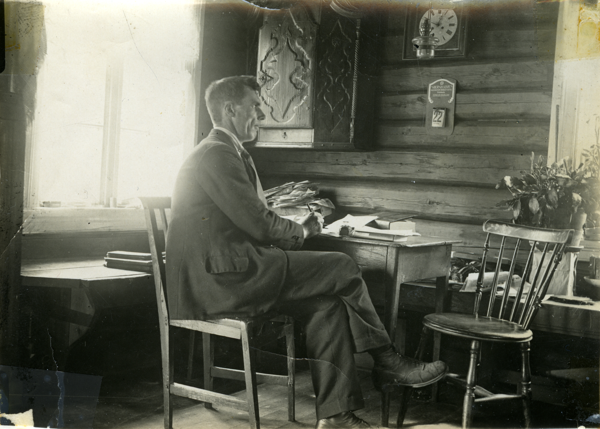 Interiør fra tømmerhus. Ved skrivebordet Endre Bringo. Han hadde tidlig fotoapparat og var mye rundt og fotograferte. Hallingdal Museum har flere av bildene hans i arkivet og fotoapparatet er gitt til museet.
