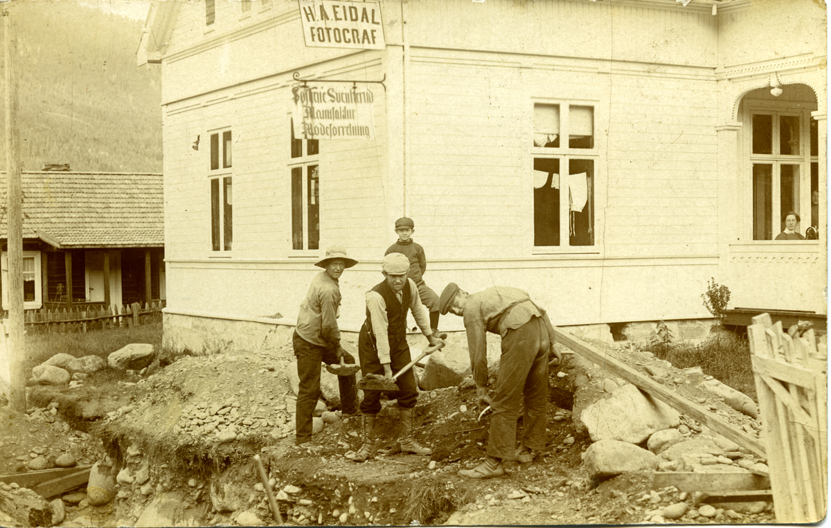 Grøftegraving ca. 1920. Innlegging av vann i H. A. Eidals butikk. Fotograf Eidal og Søstrene Svenkeruds Moteforretning.
Legg merke til utstillingen i vinduene. I bagrunnen ser vi stua til Mari og Anton Lindahl. Første hovedvannledningen
ble i Nesbyen kom ca. 1913. (Se også 2861a)
