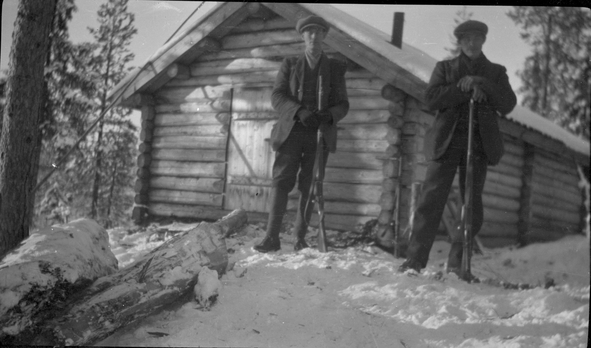 Jakt. Jergere foran skogshusvær - koie.
