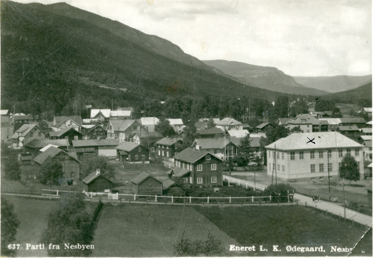 Tettsted. Postkort fra Nesbyen med folkeskolen  og Klokkergården ( nå i Hemsedal)i forgrunn.
