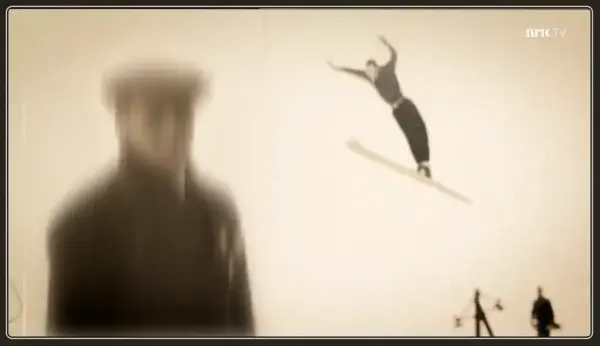 Fra filmen, uskarp mannsskikkelse med skihopper i luften over