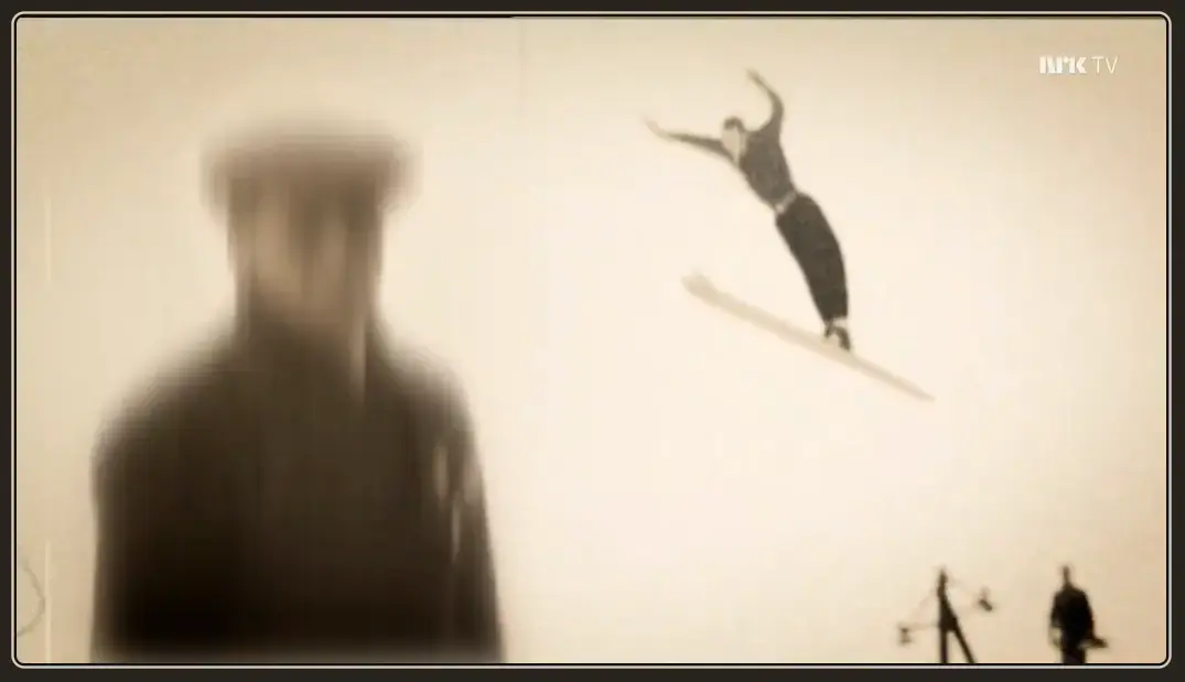 Fra filmen, uskarp mannsskikkelse med skihopper i luften over