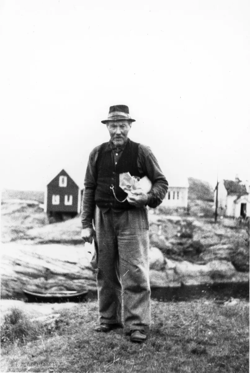 Iver Elias Nilsen, f.1873. Stående på Inste Holmen (Søre Bjørnsund), med husene på Yste Holmen i bakgrunnen.