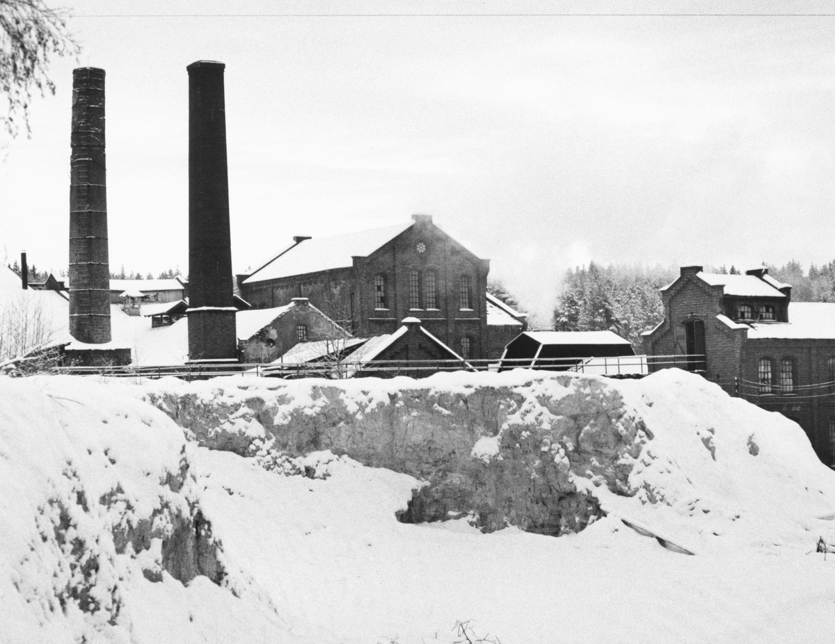 Vinter ved den nedlagte papirfabrikken på Klevfos, Ådalsbruk i Løten, Hedmark. Det ryker fra fabrikken. Klevfos cellulose og papirfabrikk.