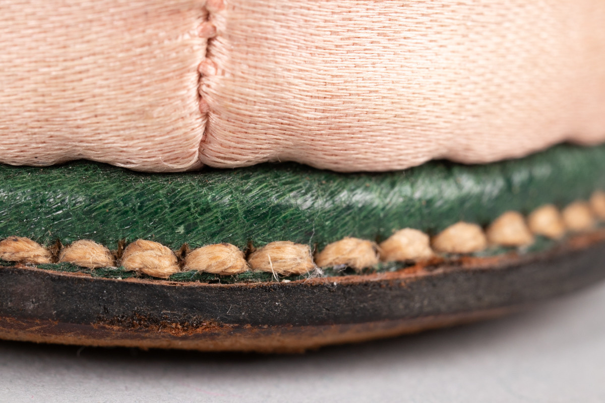 Rosa, håndsydd damesko eller tøffel i silke med spiss tå og flat lærsåle uten hæl. Dekorert med rosett med paljetter på rista.