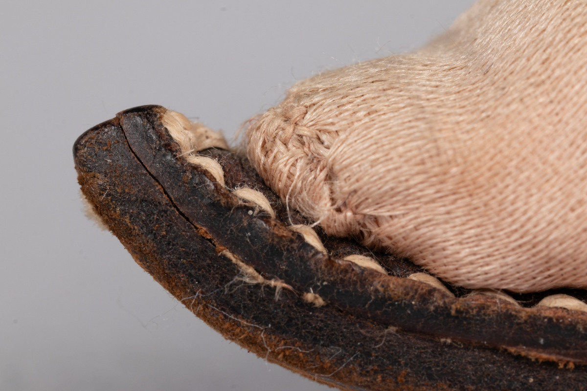 Rosa, håndsydd damesko eller tøffel i silke med spiss tå og flat lærsåle uten hæl. Dekorert med rosett med paljetter på rista.