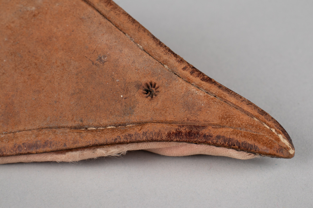 Rosa, håndsydd damesko eller tøffel i silke med spiss tå og flat lærsåle uten hæl. Dekorert med rosett med paljetter på rista.